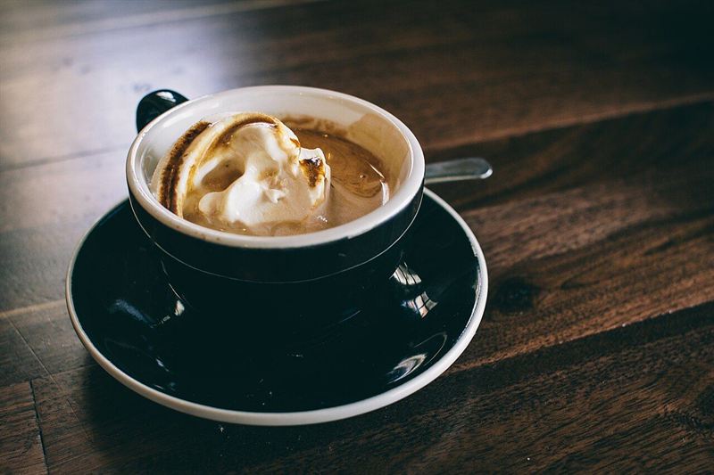 白いカップに注がれた、湯気の立つブラックコーヒー